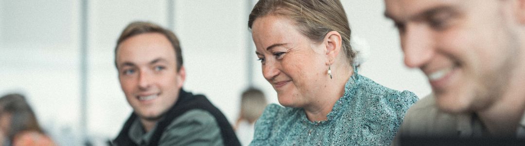 Tre smilende kolleger fra Human House arbejder sammen