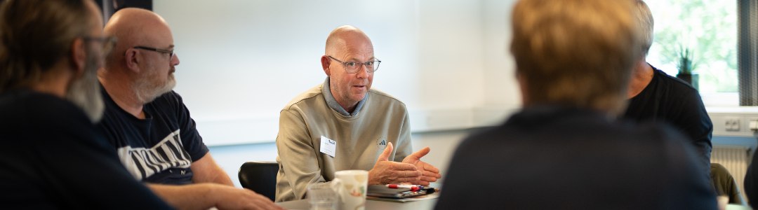 Kommunikation redder liv (3) En gruppe af mennesker, der sidder og kommunikerer om arbejdsmiljø
